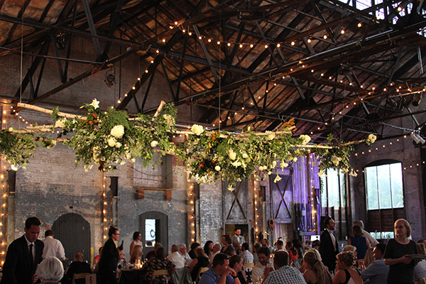 A barn transforms into a romantic wedding venue with twinkling lights and elegant floral arrangements adorning every corner.